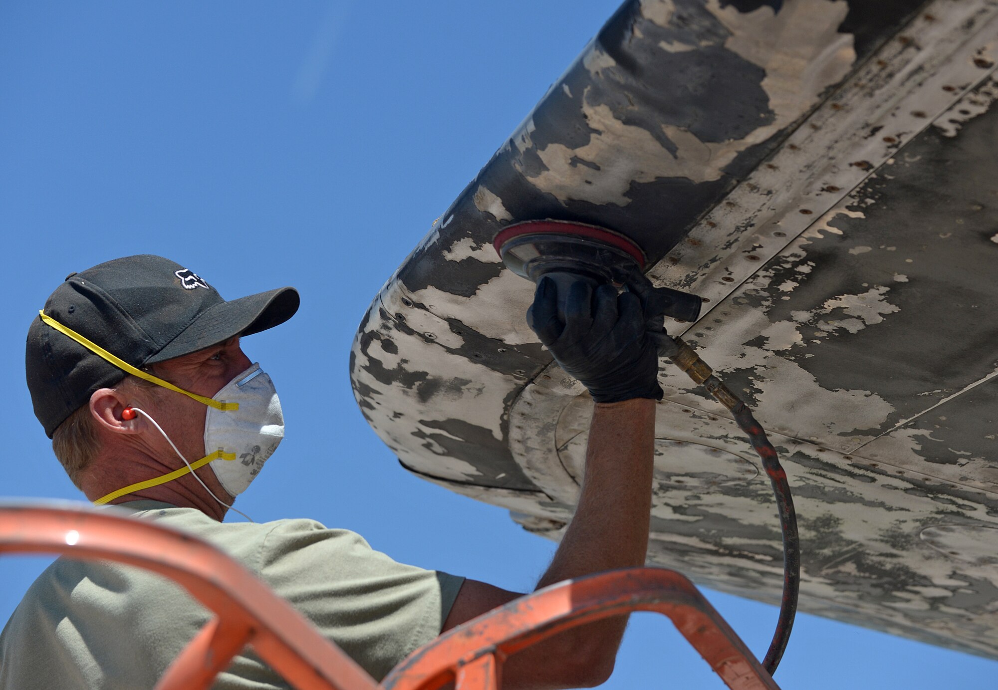 Envirotech Environmental Services employee Keith Williams applies a sander to the flacking paint on B-29 Superfortress, S/N 44-86408 "Haggerty's Hag," at the Hill Aerospace Museum. The B-29 is one of sevearal display items getting a fresh coat of paint. (U.S. Air Force photo/Alex R. Lloyd)