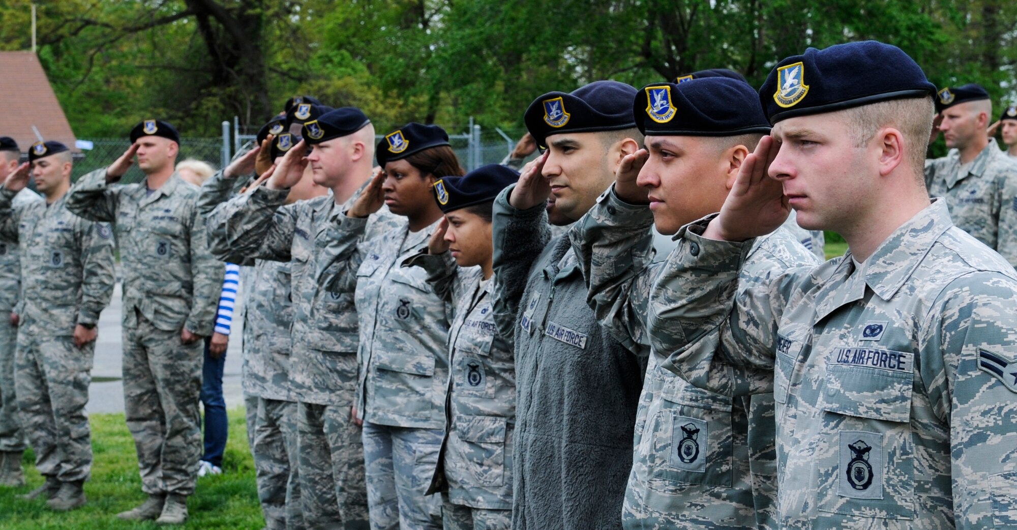 Security forces members salute during a retirement ceremony for three military working dogs on Joint Base Andrews, Md., May 1, 2015. Following the ceremony, the dogs were adopted out to former canine handlers and security forces members. (U.S. Air Force photo/ Senior Airman Mariah Haddenham)