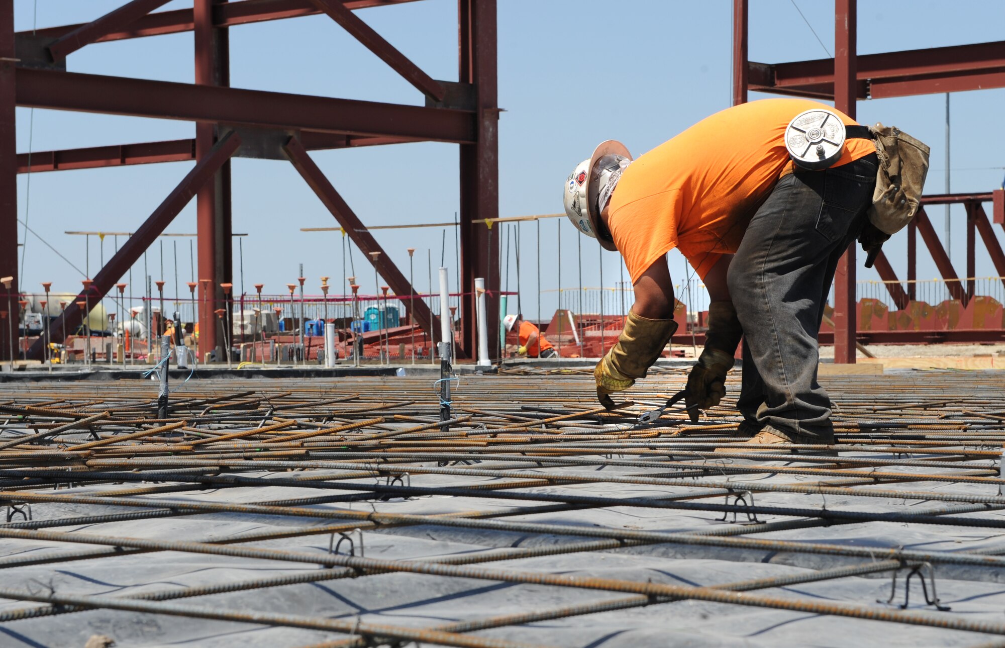 A construction worker secures a piece of rebar to the floor of Hangar 1125, April 30, 2015, at McConnell Air Force Base, Kan. The rebar reinforces the concrete floor once it is poured. Hangar 1125 will be used for general maintenance on the KC-46A Pegasus once it is delivered to McConnell, which is scheduled to happen in August 2016. (U.S. Air Force photo by Staff Sgt. Rachel Waller)  