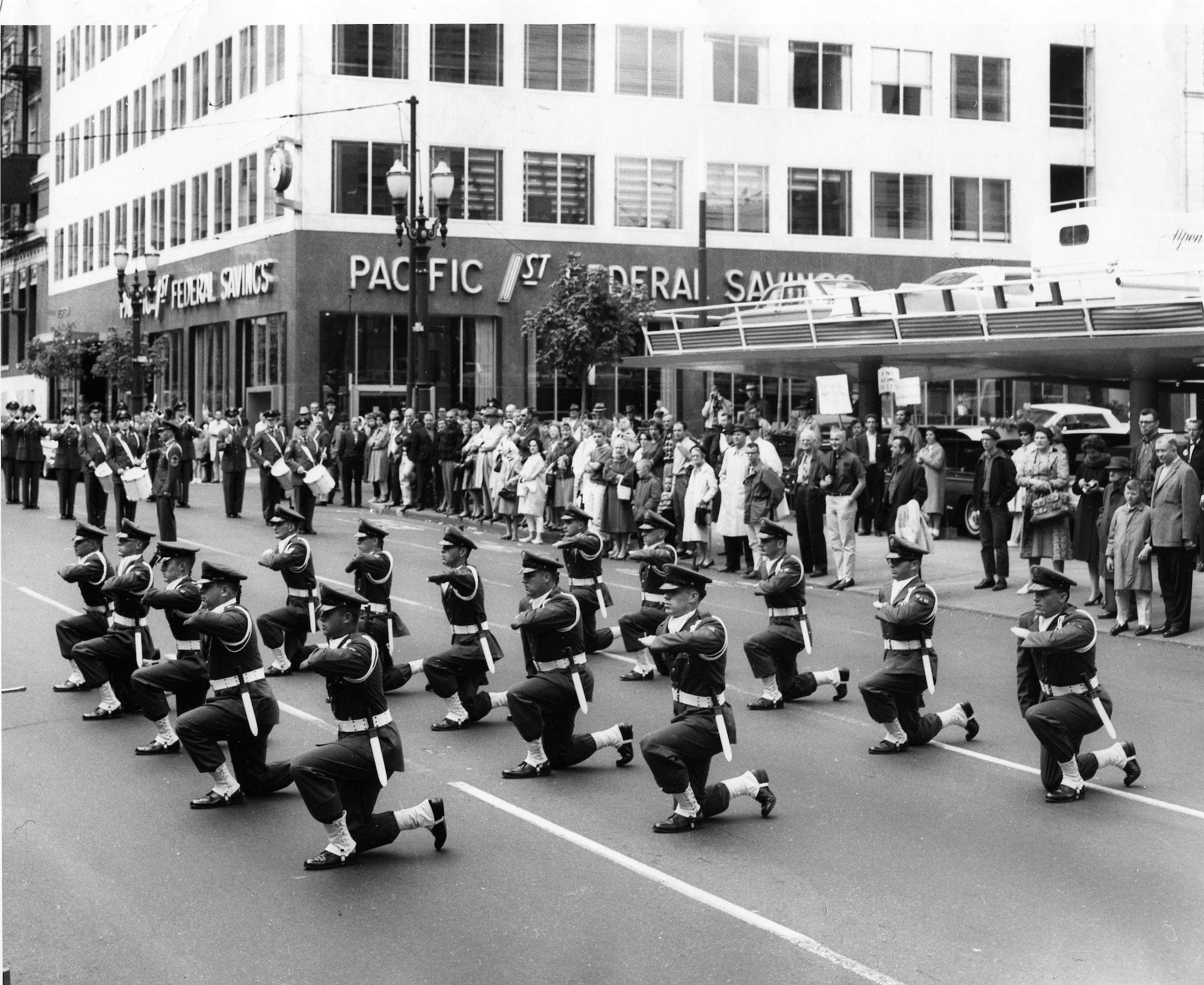 A slightly larger formation of OreANG Precision Rifle Drill Team members perform their signature “Queen Anne Salute” in front of the reviewing stand during a parade in downtown Portland in the early 1960’s.  (142FW History Archives)