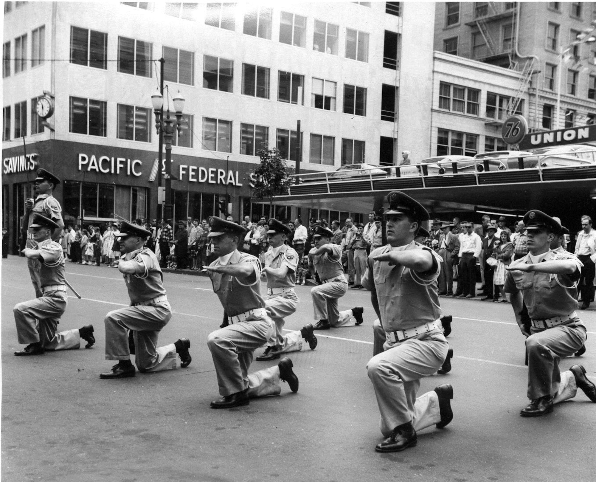 OreANG Precision Rifle Drill Team members perform the “Queen Anne Salute” in front of the official reviewing stand during the May 20, 1961, Armed Forces Day Parade in downtown Portland, near the Pioneer Square post office.  Note the Team Leader with sword raised to left.  (142FW History Archives)