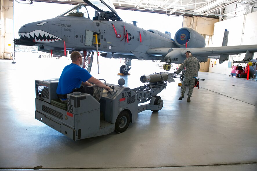 U.S. Air Force Tech. Sgt. John Chapman, 74th Aircraft Maintenance Unit weapons load team chief, right, guides Senior Airman Travis Banks, 74th AMU weapons load crew member, during the weapons load crew of the quarter competition April 24, 2015, at Moody Air Force Base, Ga. A Guidance Control Unit was installed after the GBU-12 missile was secured on the bomb rack. (U.S. Air Force photo by Airman Greg Nash/Released)