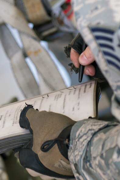 U.S. Air Force Tech. Sgt. John Chapman, 74th Aircraft Maintenance Unit weapons load team chief, documents actions completed in a technical orders book during the weapons load crew of the quarter competition April 24, 2015, at Moody Air Force Base, Ga. Technical orders for the weapons load crew members contain instructions on how to properly load weapons on aircraft. (U.S. Air Force photo by Airman Greg Nash/Released)