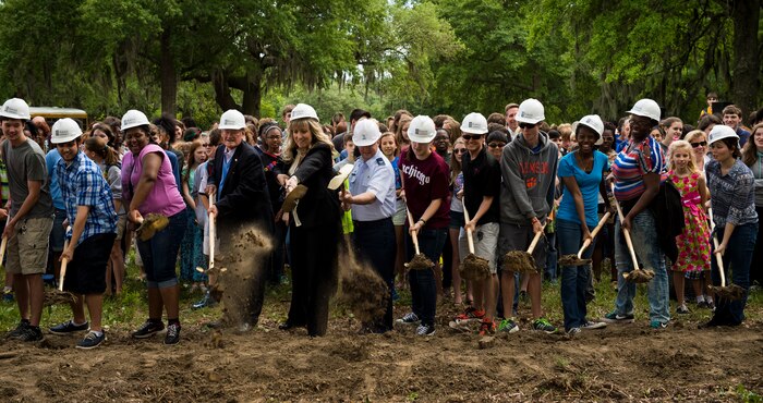 Bob King, North Charleston councilman (middle left), Stacey Lindbergh, Palmetto Scholars Academy Board of Directors chairman (center); Col. Jeffrey DeVore, Joint Base Charleston commander (middle right); along with members of the Palmetto Scholars Academy senior class break ground on the school's permanent location in Hunley Park, Joint Base CHarleston, S.C., May 1, 2015.  The ground breaking ceremony is the next step in what has been a 3 1/2 year partnership between JB Charleston and the Lowcountry community. The South Carolina Legislature introduced and passed unanimously the S.C. Military Charter Law, which provides PSA the ability to set aside slots in its annual lottery for children of active duty military assigned to JB Charleston. PSA is scheduled to open during the 2015-2016 academic year. (U.S. Air Force photo / Airman 1st Class Clayton Cupit)