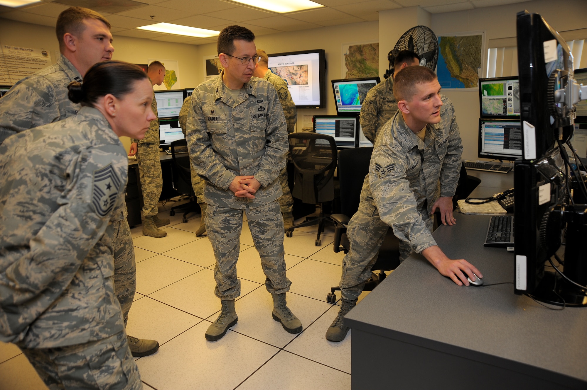 Senior Airman Charles Morgan, 25th Operational Weather Squadron, briefs  Col. William J. Carle, 557th Weather Wing commander, and Chief Master Sgt. Terri Grebel, 557th WW command chief, on the capabilities of the Smart Worksheet 4 at Davis-Monthan Air Force Base, Arizona, April 23, 2015. The Smart Worksheet 4 allows the 25th OWS to communicate weather forecast with all Air Force weather squadrons across the U.S. The 25th OWS is a tenant unit at Davis-Monthan AFB and its higher headquarters is the 577th WW at Offutt Air Force Base, Nebraska. (U.S. Air Force photo by Staff Sgt. Angela Ruiz)