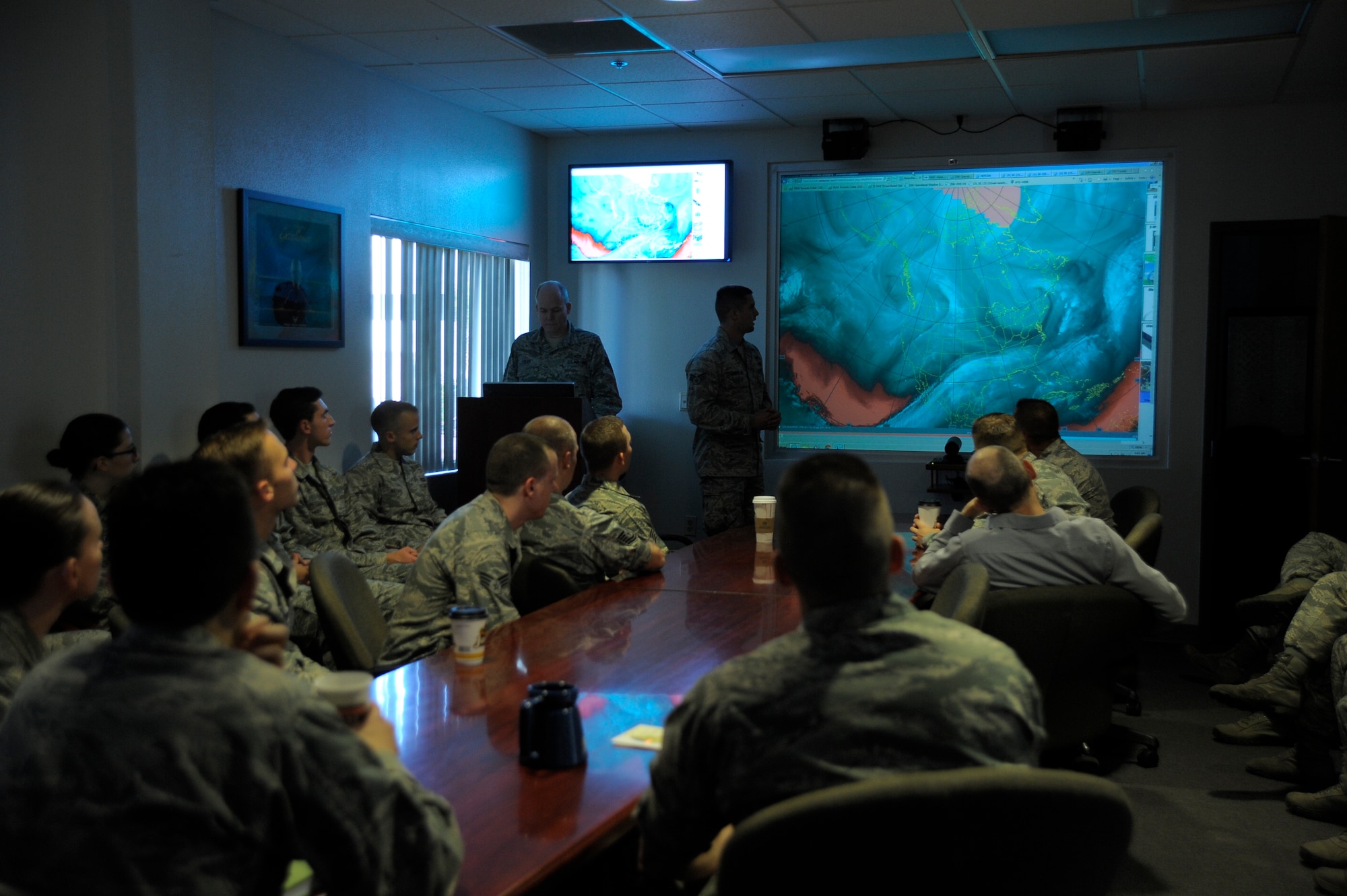 The 25th Operational Weather Squadron briefs Col. William J. Carle, 557th Weather Wing commander, on weather conditions during his visit to Davis-Monthan Air Force Base, Arizona, April 23, 2015. The mission of the 25th OWS is to provide accurate, timely, and relevant weather analyses, forecasts, warnings, and briefings to Air Force, Army, National Guard, Reserve, and Combatant Command forces operating in the western continental United States, Canada and Mexico. The 25th OWS is a tenant unit at Davis-Monthan AFB and its higher headquarters is the 577th WW at Offutt Air Force Base, Nebraska. (U.S. Air Force photo by Staff Sgt. Angela Ruiz)