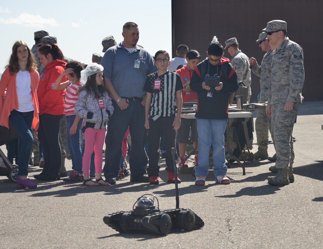 Onlookers watch as Justin Burton, 12, operates a robot as part of an explosive ordnance disposal demonstration at the 58th Special Operations Wing's Bring Your Kids to Work Day event April 23. (Photo by Todd Berenger)