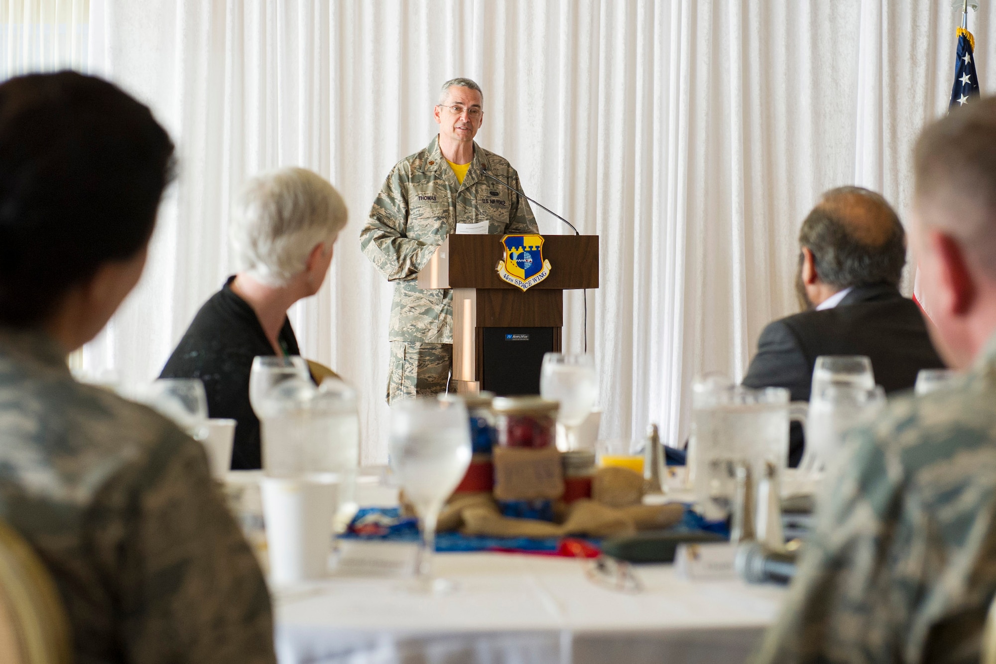 Chaplain (Maj.) Mark Thomas, 45th Space Wing protestant chaplain, introduces the guest speaker during the National Prayer Breakfast, May 1, at the Tides Club at Patrick Air Force Base, Fla. Each representative shared their religious reading with Team Patrick-Cape on the topic related to the difference between hearing and listening. (U.S. Air Force photo/Matthew Jurgens) 