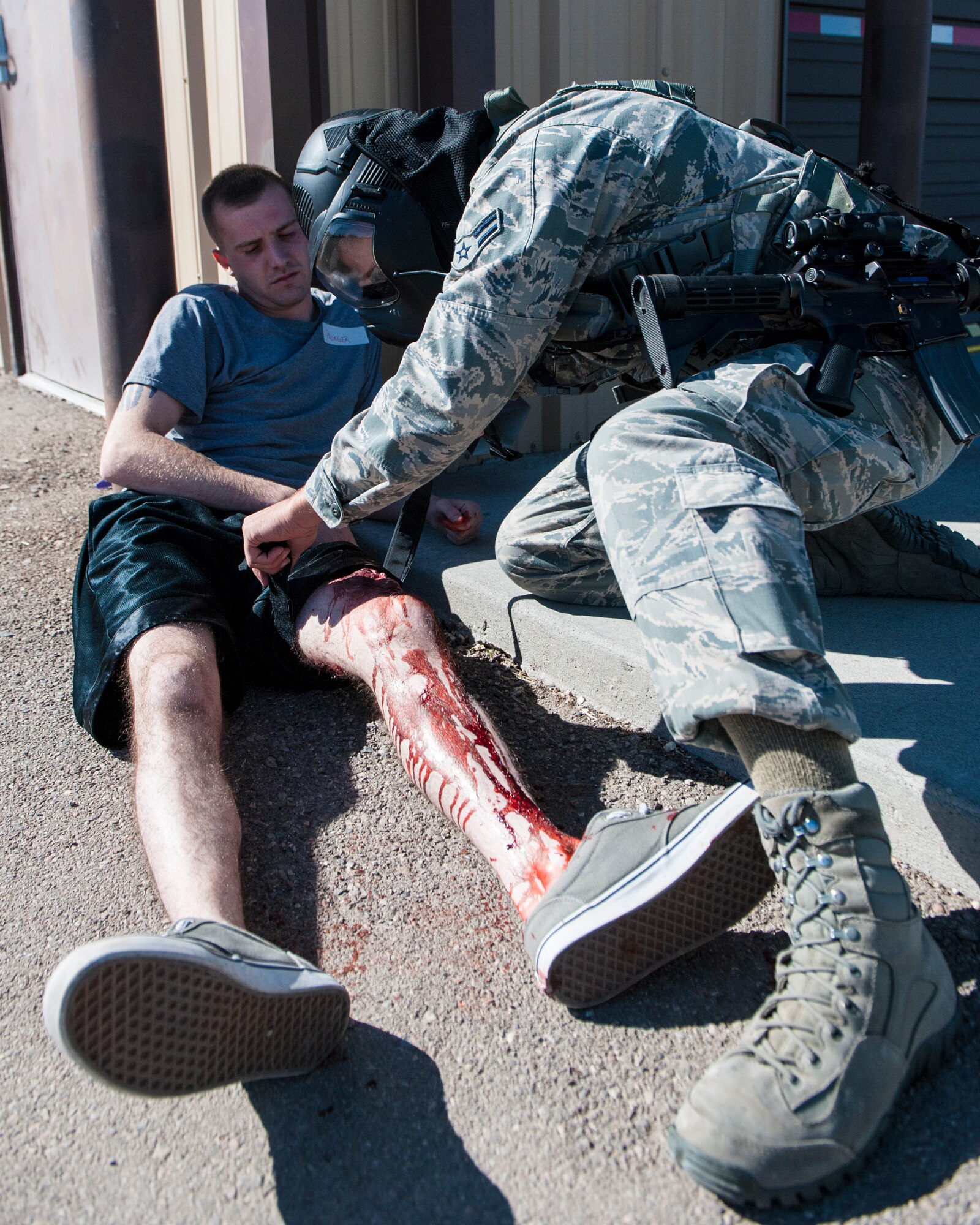 A member of the 49th Security Forces Squadron provides self-aid-buddy care on a “victim” during an active shooter exercise April 30, 2015 at Holloman Air Force Base, N.M. Members from the SFS responded to, and neutralized the threat. The 49th Civil Engineer Squadron and the 49th Medical Group provided medical support to the “victims.” (U.S. Air Force Photo by Airman 1st Class Emily A. Kenney/Released)