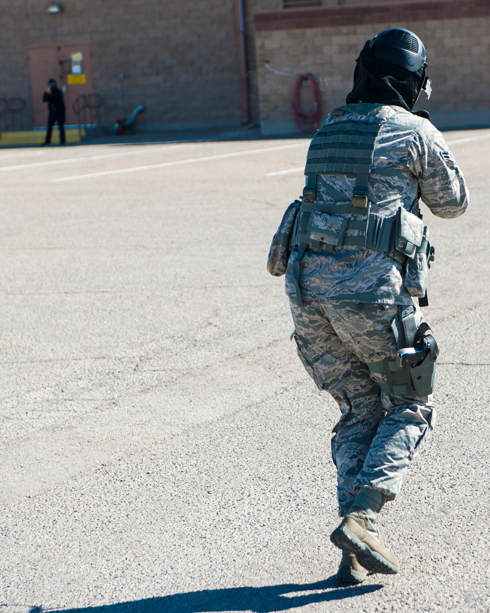 A member of the 49th Security Forces Squadron engages with an active shooter during an active shooter exercise at April 30, 2015 at Holloman Air Force Base, N.M. During the exercise, SFS members cleared buildings, and went head-to-head with the active shooter, before providing self-aid-buddy care to the casualties. (U.S. Air Force photo by Airman 1st Class Emily A. Kenney/Released)  