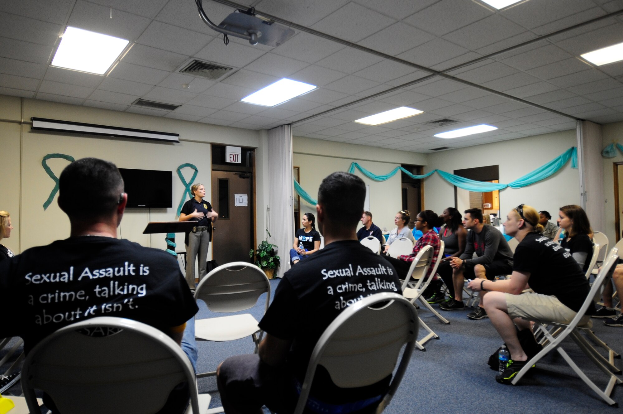 Desiree Santillan, U.S. Air Force Office of Special Investigations agent, spoke to the marchers about the importance of mandatory reporting inside Chapel 2 on Kadena Air Base, Japan, May 1, 2015.  She emphasized how leaders can make the difference in reporting even though it may be hard or cause them difficulty. (U.S. Air Force photo/Senior Airman Omari Bernard)