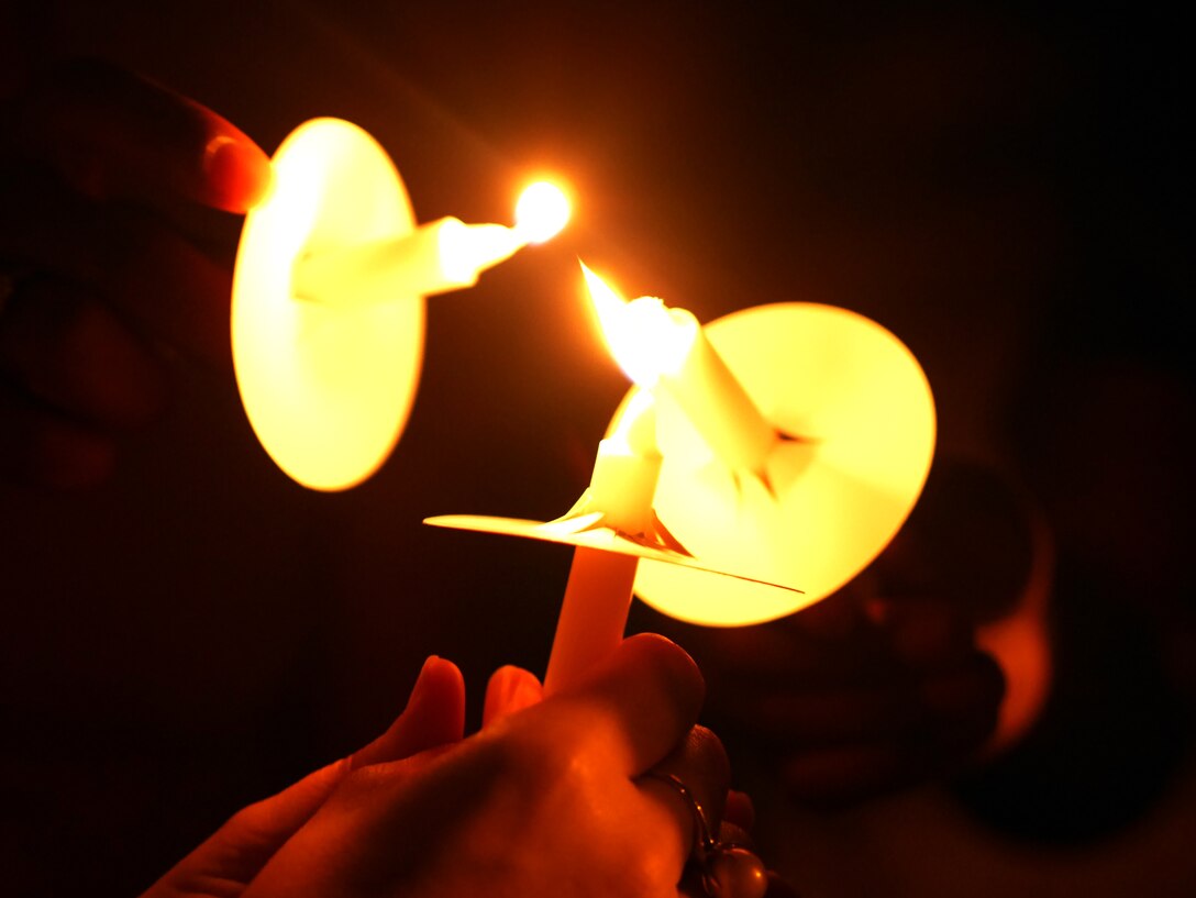 Victim advocates light candles during the Take Back the Night march on Kadena Air Base, Japan, May 1, 2015. Each individual lights the candles of those around them to illuminate the night and symbolize unity and togetherness. (U.S. Air Force photo/Senior Airman Omari Bernard)