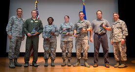 Col. John Lamontagne, 437th Airlift Wing commander, and CMSgt Shawn Hughes, 437th AW command chief, congratulate the award winners of the 437th AW 1st Quarterly Awards April 30, 2015, at the base theater on Joint Base Charleston, S.C. The Quarterly Awards are held to recognize outstanding Airmen, non-commissioned officers, senior non-commissioned officers, company grade officers and civilians for their hard work and dedication. The winners displayed are (left to right) Senior Master Sgt. Chad Neubarth, SNCO of the Quarter, Tech. Sgt. Danaly Holder, NCO of the Quarter, Airman 1st Class Brandilyn Grant, Airman of the Quarter, 1st Lt. David Snyder, CGO of the Quarter and Mr. James Moore, Civ Cat II of the Quarter.  (U.S. Air Force photo/ Airman 1st Class Clayton Cupit) 
