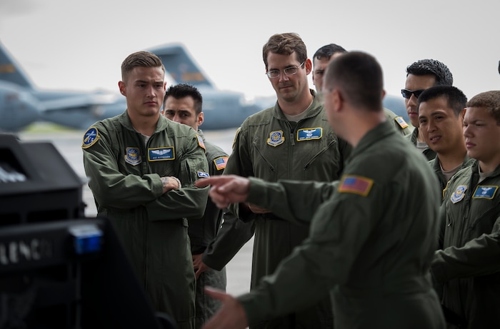 Loadmasters from the 14th Airlift Squadron go over winching procedures April 29, 2015, for a C-17 Globemaster III on Joint Base Charleston, S.C. The 14th AS, 437th Logistics Readiness Squadron, 437th Maintenance Group, Mt. Pleasant Special Weapons And Tactics, Dorchester County Sheriff’s Office and 437th Ariel Port Squadron conducted a static loading exercise with simulated Mine-Resistant Ambush Protected vehicles. The exercise included loading, winching and aircraft refueling training for newly deploying loadmasters. (U.S. Air Force photo/Airman 1st Class Clayton Cupit)