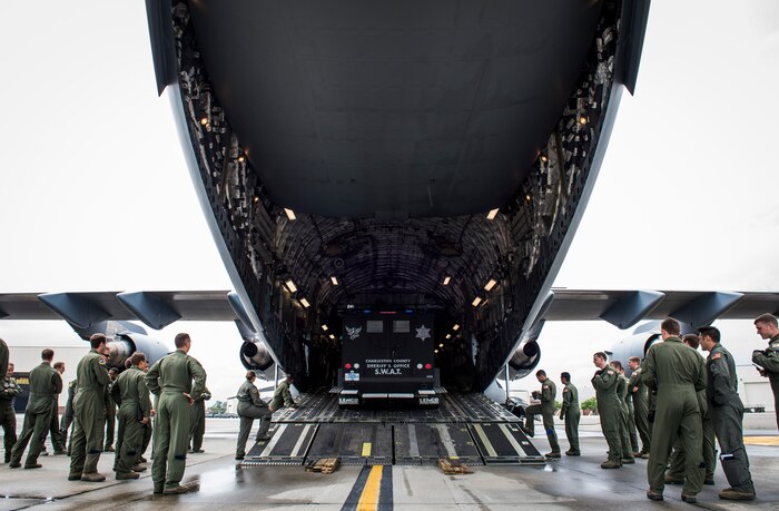 Loadmasters from the 14th Airlift Squadron watch a Charleston County Sheriff’s Office Special Weapons and Tactics vehicle get winched into a C-17 Globemaster III April 29, 2015, on the flightline at Joint Base Charleston, S.C. The 14th AS, 437th Logistics Readiness Squadron, 437th Maintenance Group, Mt. Pleasant SWAT, Dorchester County Sheriff’s Office and 437th Ariel Port Squadron conducted a static loading exercise with simulated Mine-Resistant Ambush Protected vehicles. The exercise included loading, winching and aircraft refueling training for newly deploying loadmasters. (U.S. Air Force photo/Airman 1st Class Clayton Cupit)