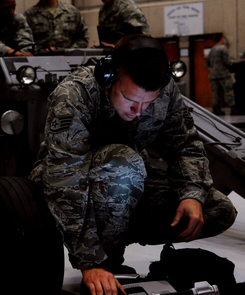 Members of Team Whiteman go through the process of repairing a damaged loading vehicle during a weapons load competition at Whiteman Air Force Base, Mo., April 10, 2015. The competition is held quarterly between various load teams, with four different phases of the competition. (U.S. Air Force photo/Airman 1st Class Jovan Banks/Released)