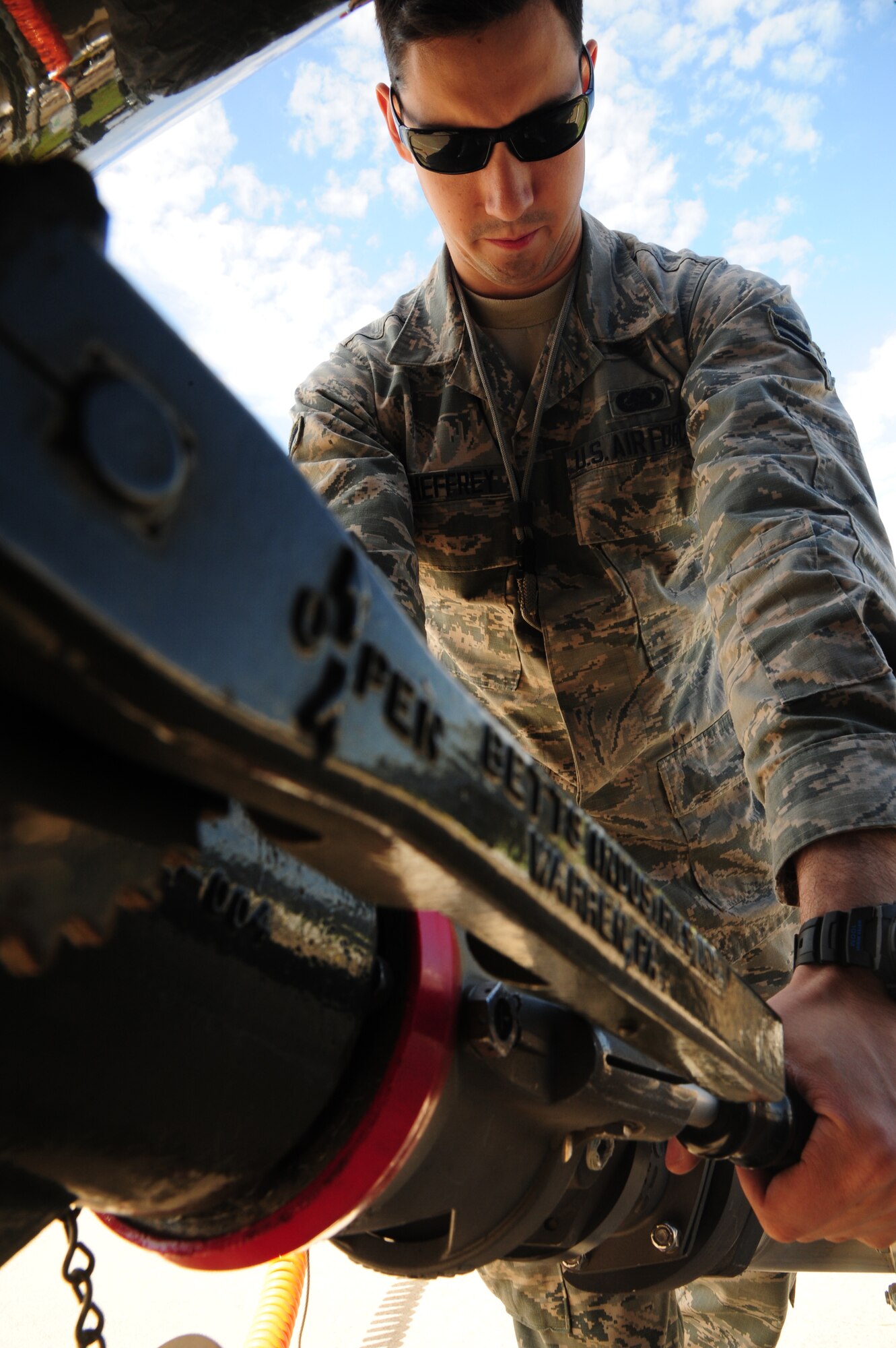 Airman 1st Class Jake McSheffrey, 509th Logistics Readiness Squadron fuels distribution technician, attaches a single point nozzle to an R-11 truck at Whiteman Air Force Base, Mo., April 23, 2015. The single point nozzle attaches to the bottom loader, to verify that the metered fill issued prior to filling. (U.S. Air Force photo by Senior Airman Keenan Berry/Released)