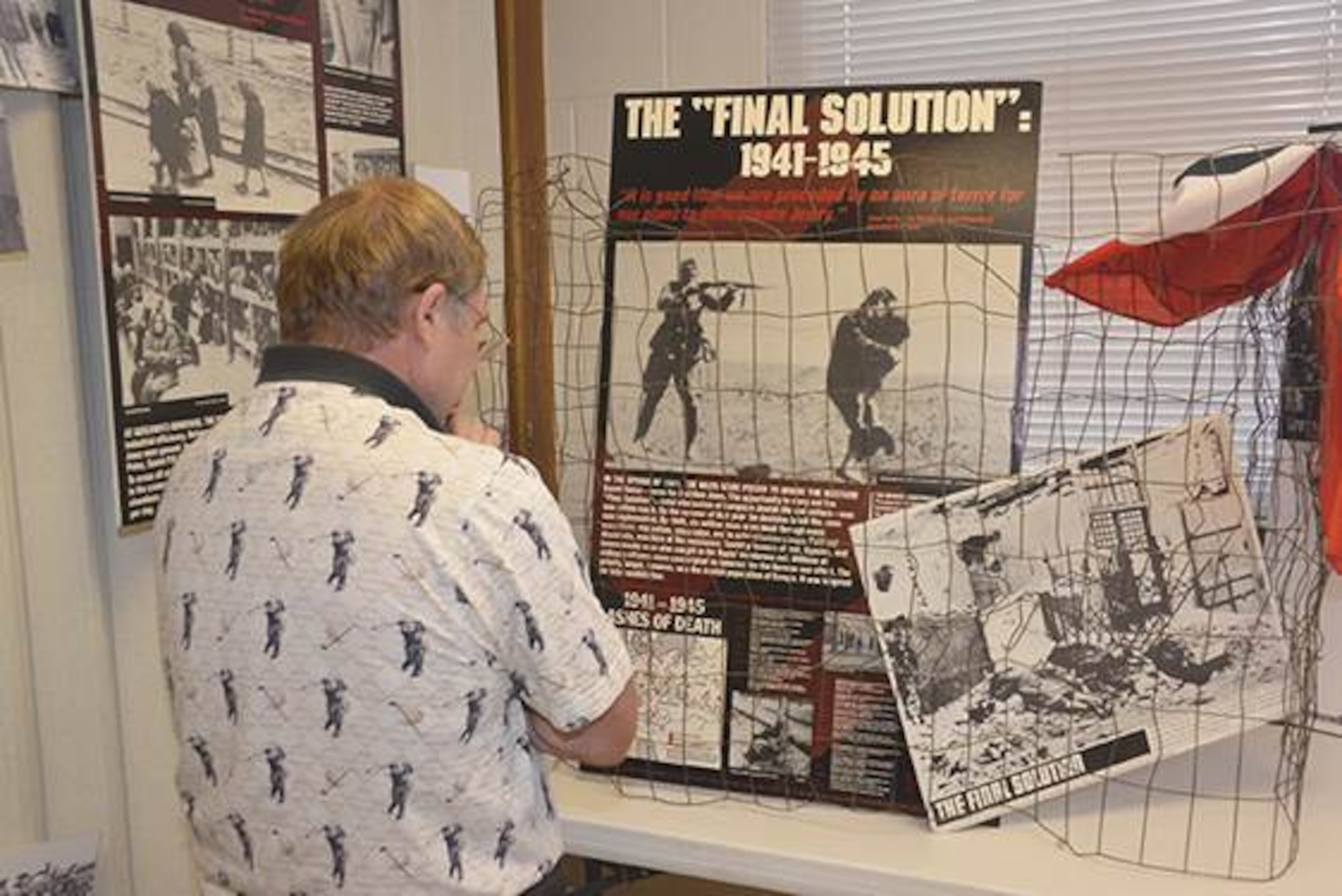 A member of the Kirtland community views part of a chronological series of exhibits at Kirtland’s Holocaust Remembrance Day event April 23. (Photo by Dennis Carlson)