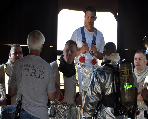 During the May Unit Training Assembly, Col. Bruce Cox, commander of the 307th Bomb Wing, Command Chief Master Sgt. Randal Noble of the 307 BW and Command Chief Master Sgt. Thomas Mazzone of the 2nd BW, all located at Barksdale Air Force Base, La., get familiar with the inside of the firefighting training simulator before they suit up to fight a fire. When they return the simulator will be fully involved in a fire with limited visibility and temperatures over 2,000 degrees Fahrenheit. (U.S. Air Force photo by Master Sgt. Laura Siebert/Released)