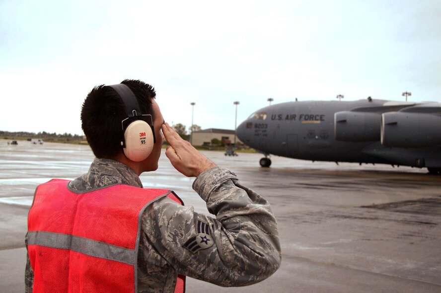 Air Force Senior Airman Chad Sebok, a C-17 Globemaster III crew chief from the 62nd Aircraft Maintenance Squadron, Joint Base Lewis-McChord, Wash., salutes the pilot after launching his aircraft for a Combined Joint Operational Access Exercise 15-01 sortie on Apr. 16, 2015, Pope Army Airfield, N.C. CJOAX 15-01 is an 82nd Airborne Division-led bilateral training event at Fort Bragg, N.C., from April 13-20, 2015. This is the
largest exercise of its kind held at Fort Bragg in nearly 20 years and demonstrates interoperability between U.S. and U.K. Army soldiers and U.S. Air Force, Air National Guard, Royal Air Force Airmen and U.S. Marines. (U.S. Air Force photo/Marvin Krause)
