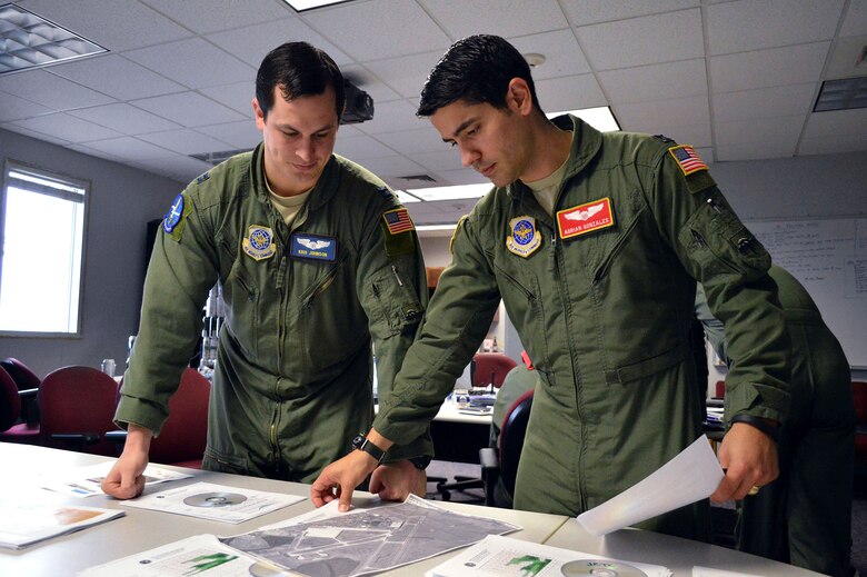 Air Force Capt. Kris Johnson, a C-17 Globemaster III pilot from the 7th Airlift Squadron, left, and Capt. Adrian Gonzales, a C-17 pilot from the 10th Airlift Squadron, Joint Base Lewis-McChord, Wash., conduct Combined Joint Operational Access Exercise 15-01 mission planning on Apr. 16, 2015, Pope Army Airfield, N.C. CJOAX 15-01 is an 82nd Airborne Division-led bilateral training event at Fort Bragg, N.C., from April 13-20, 2015. This is the largest exercise of its kind held at Fort Bragg in nearly 20 years and demonstrates interoperability between U.S. and U.K. Army soldiers and U.S. Air Force, Air National Guard, Royal Air Force Airmen and U.S. Marines. (U.S. Air Force photo/Marvin Krause)
