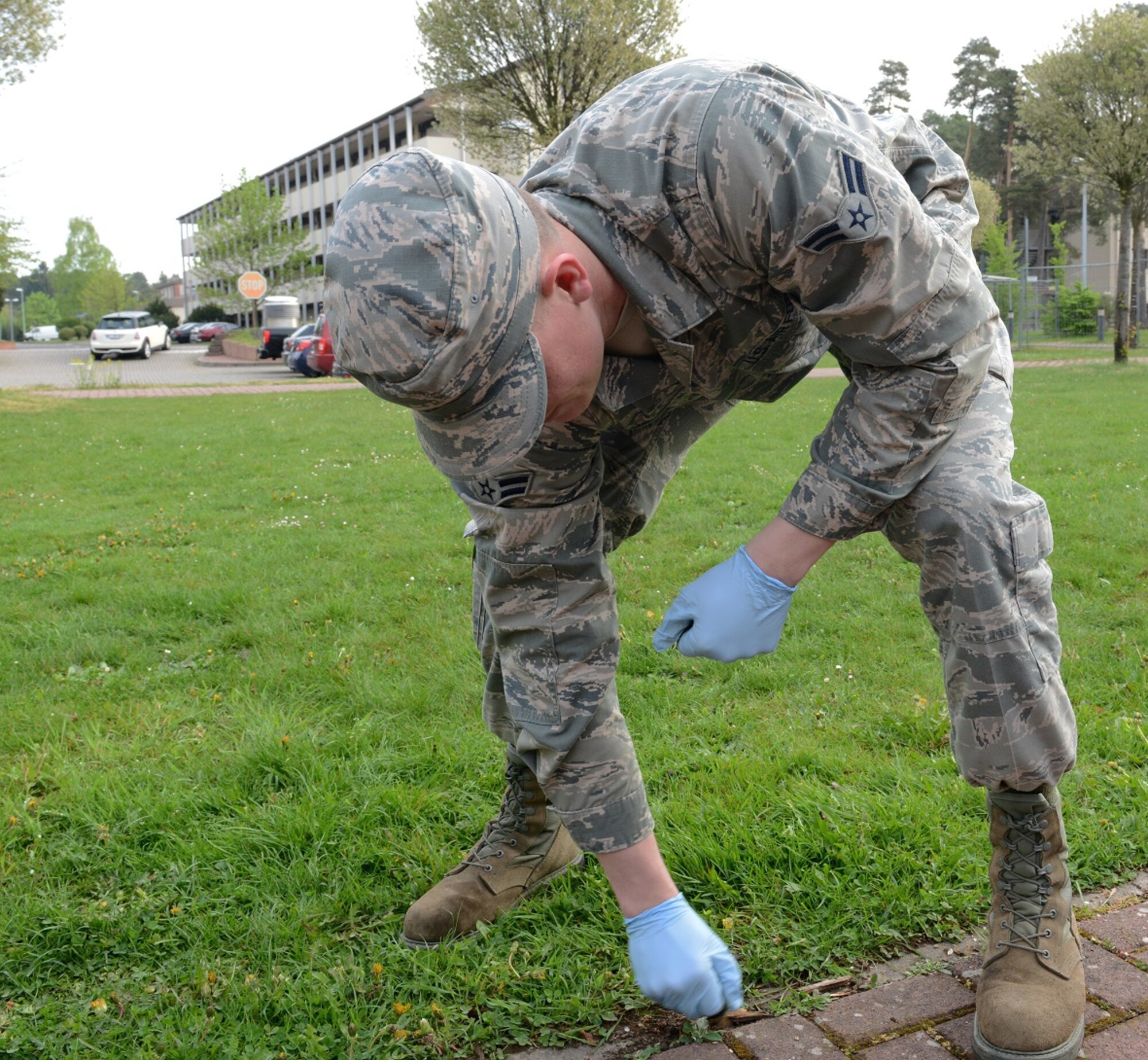 An Airman pulls weeds during Base Pride April 28, 2015, at Ramstein Air Base, Germany. The purpose of Base Pride is to ensure that all the buildings and surrounding areas look clean and professional. (U.S. Air Force photo/Airman 1st Class Tryphena Mayhugh)