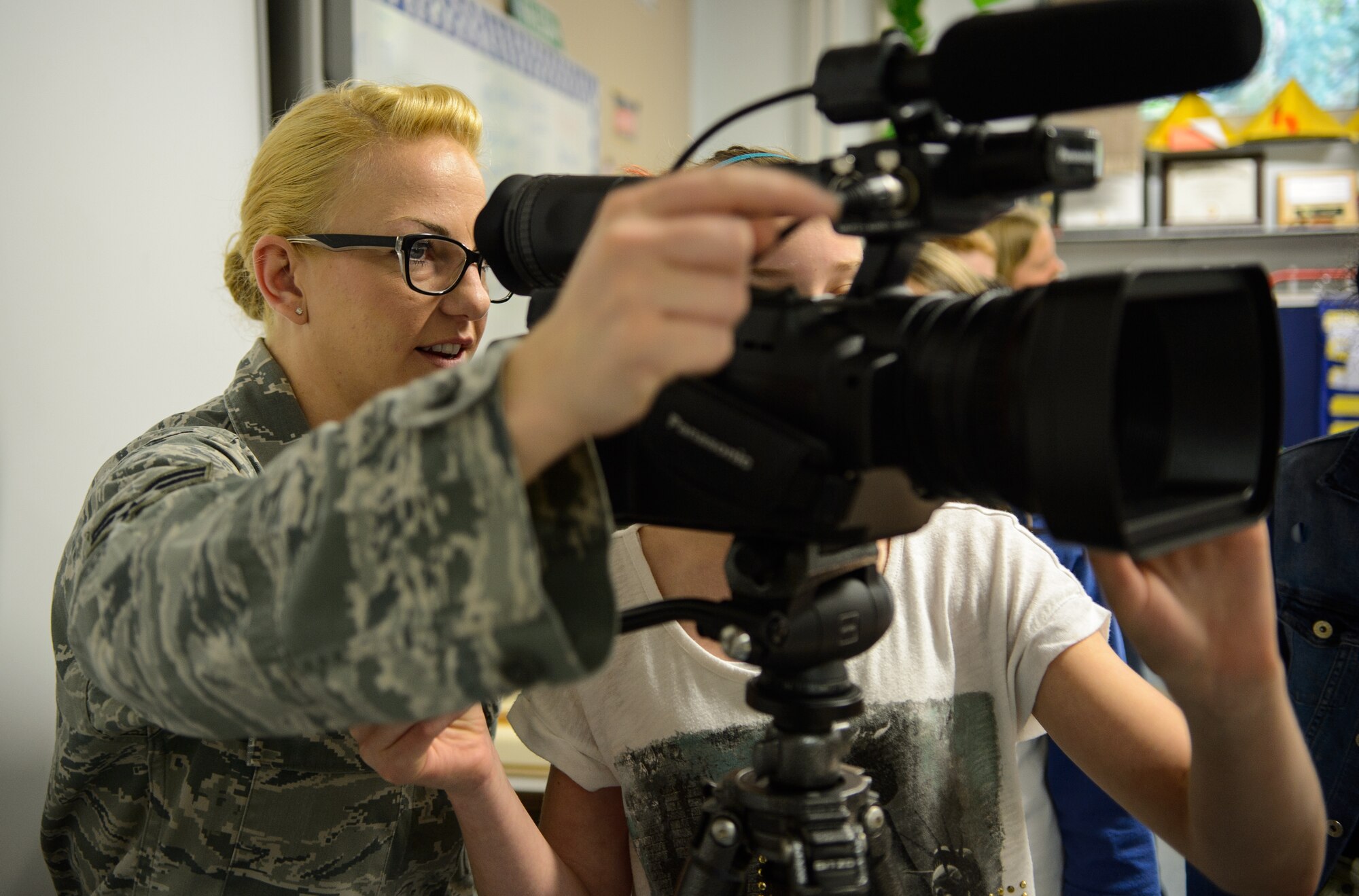 Senior Airman Lindy Pata, American Forces Network Kaiserslautern broadcaster, teaches children from Ramstein Intermediate School about her career April 28, 2015, at Ramstein Air Base, Germany. Pata and more than 100 other presenters showed off their skills, training and assets that help them support the  mission. (U.S. Air Force photo/Staff Sgt. Armando A. Schwier-Morales) 