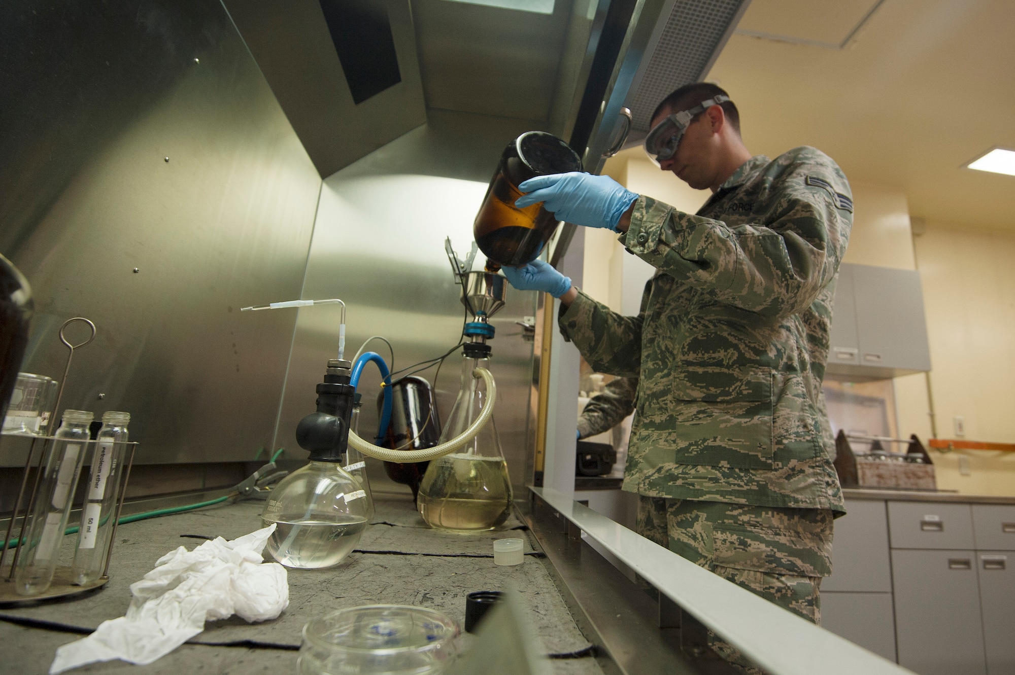 U.S. Air Force Senior Airman Brett Carter, 35th Logistics Readiness Squadron fuels laboratory technician, conducts a one-gallon sample diagnostic on aircraft fuel at Misawa Air Base, Japan, April 30, 2015. The fuel is filtered through two membranes which quantify the amount of sediment in parts per-million. This is part of a test to see how clean, and free of debris the fuel is. (U.S. Air Force photo by Senior Airman Jose L. Hernandez-Domitilo/Released)