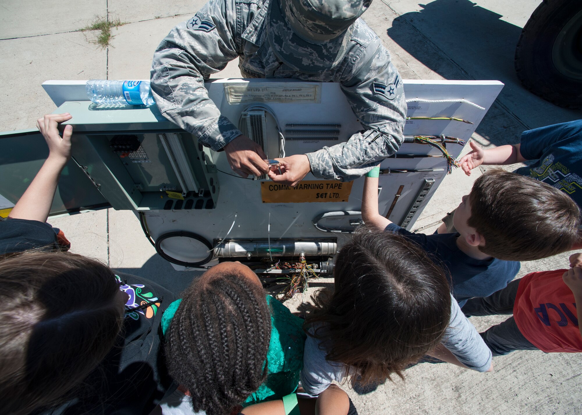 Airman 1st Class Kyle Belmares, 39th Communications Squadron cable and antenna systems technician explains the different types of cables used on Incirlik Air Base to 39th Air Base Wing dependents during the 2015 Job Shadow Day April 24, 2015, at Incirlik AB, Turkey. The dependents visited six different squadrons throughout the day. (U.S. Air Force photo by Airman 1st Class Cory W. Bush/Released)