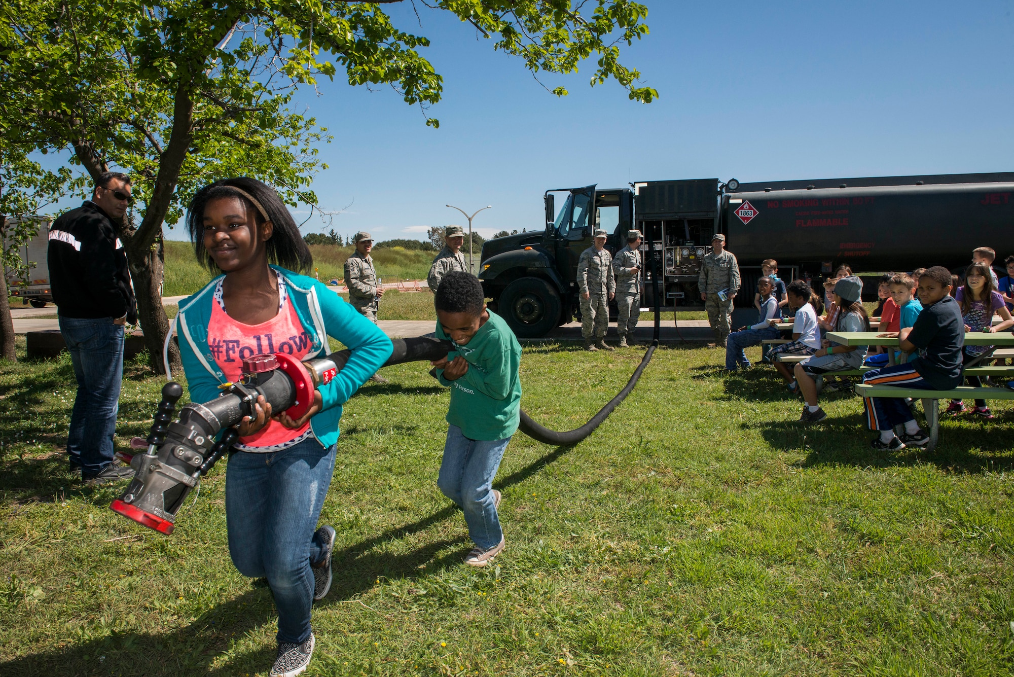 Tianni and Tyree, 39th Air Base Wing dependents roll out the hose of a fuels truck from the 39th Logistics Readiness Squadron during the 2015 Job Shadow Day April 24, 2015, at Incirlik Air Base, Turkey. Dependents called in a fuels request, rolled out the hose and tested the fuel for debris during their stop to the 39th LRS. (U.S. Air Force photo by Airman 1st Class Cory W. Bush/Released)