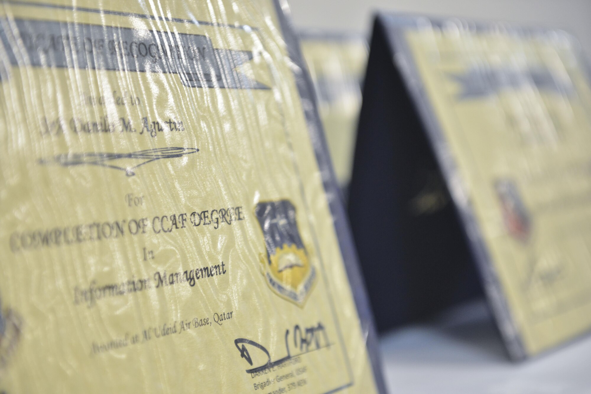 Diplomas are displayed prior to the Community College of the Air Force graduation ceremony April 28, 2015, at the Blatchford-Preston Complex theater Al Udeid Air Base, Qatar. The CCAF program was created in the 1970’s to help Airmen gain further education while earning the recognition and accreditation of college credit for Air Force training. To date, CCAF is the world’s largest multi-campus college allowing service members to continue education and earn degrees at home station, deployed or while stationed overseas. (U.S. Air Force photo/Staff Sgt. Alexandre Montes)