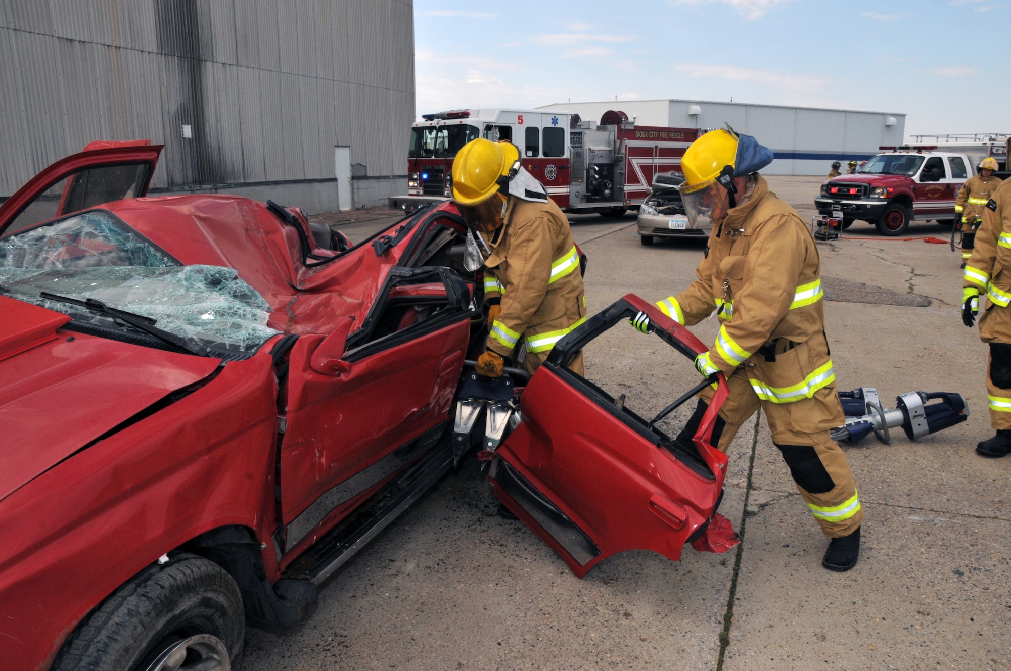 Members of the 185th Air Refueling Wing Fire Protection Services Flight, along with other local fire and rescue groups, practice using the tools and techniques to extract victims from vehicles during a mass casualty exercise at the Sioux Gateway Airport/Col. Bud Day Field in Sioux City, Iowa on Saturday May 2, 2015.  (U.S. Air National Guard photo by Tech. Sgt. Bill Wiseman/Released) 