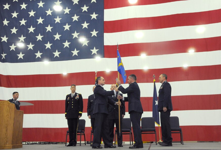 U.S. Air Force Col. Kirk Pierce, 173rd Fighter Wing Commander, passes a guideon to Col Jeffrey Smith symbolizing Smith's assumption of command of the 173rd Maintenance Group at Kingsley Field, Ore. April 12, 2015.  Smith is taking over for Col. Matt Andrews who will be retiring in May.  (U.S. Air National Guard photo by Senior Airman Penny Snoozy/Released)