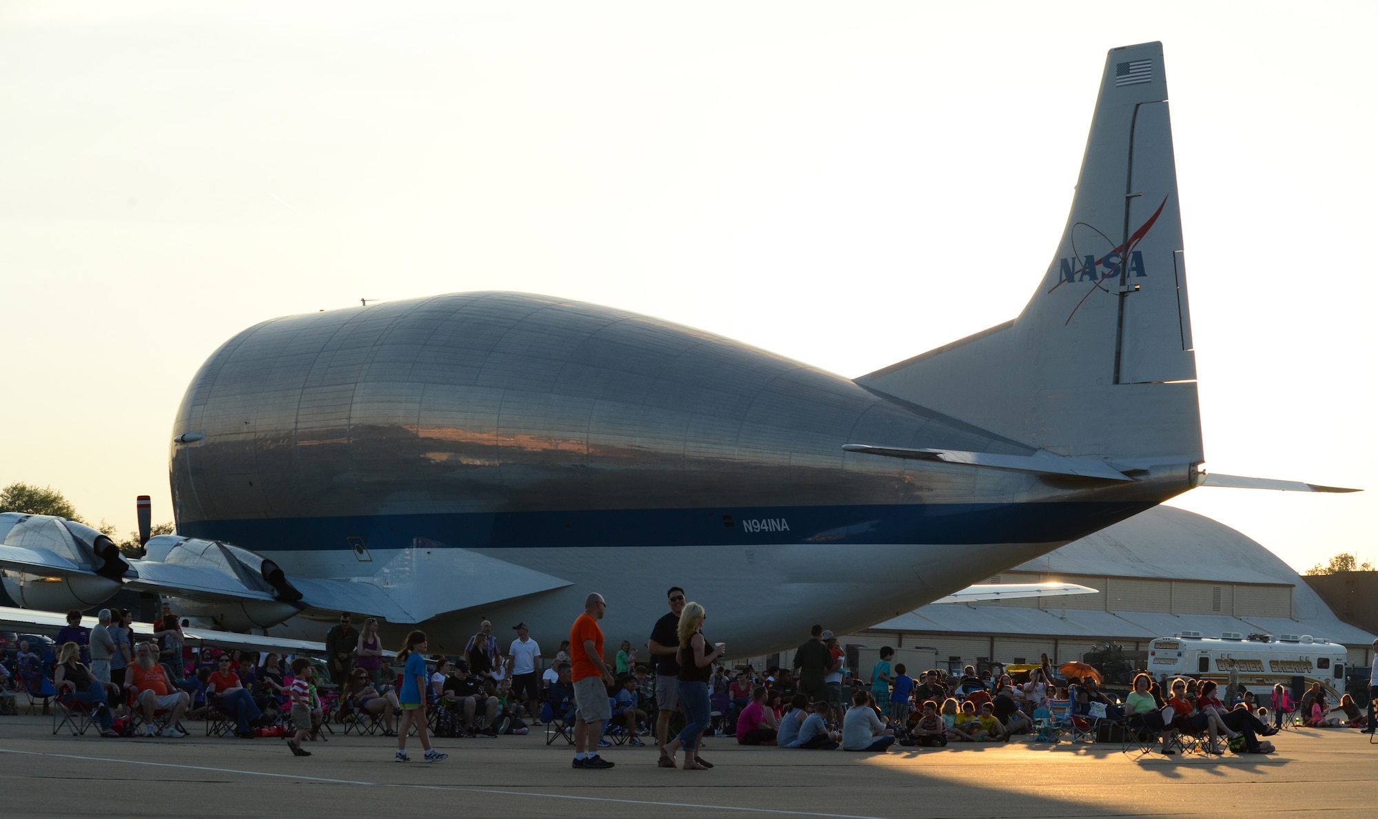Spectators take shade behind a NASA B-377 Super Guppy during the 2015 Defenders of Liberty Air Show at Barksdale Air Force Base, La., May 1. The Super Guppy has a cargo compartment that is 25 feet tall, 25 feet wide and 111 feet long. It can carry a maximum payload of more than 26 tons. The aircraft has unique hinged nose that can open more than 200 degrees, allowing large pieces of cargo to be loaded and unloaded from the front. (U.S. Air Force photo/Senior Airman Benjamin Gonsier)
