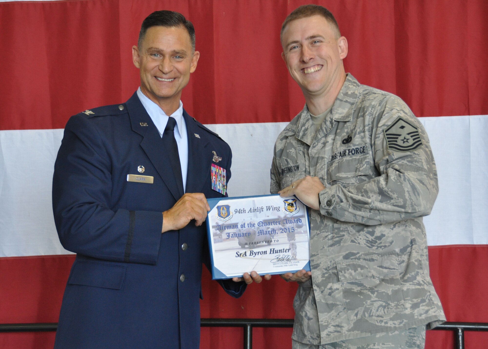 Master Sgt. Ryan Bufington, 94th Security Forces Squadron first sergeant, receives the 2015 first quarter airman of the quarter award for Senior Airman Byron Hunter, of the 94th SFS, at Dobbins Air Reserve Base, Ga, May 2. Hunter was one of many individuals to be recognized at the Commander’s Call that day. (U.S. Air Force photo/ Senior Airman Miles Wilson)