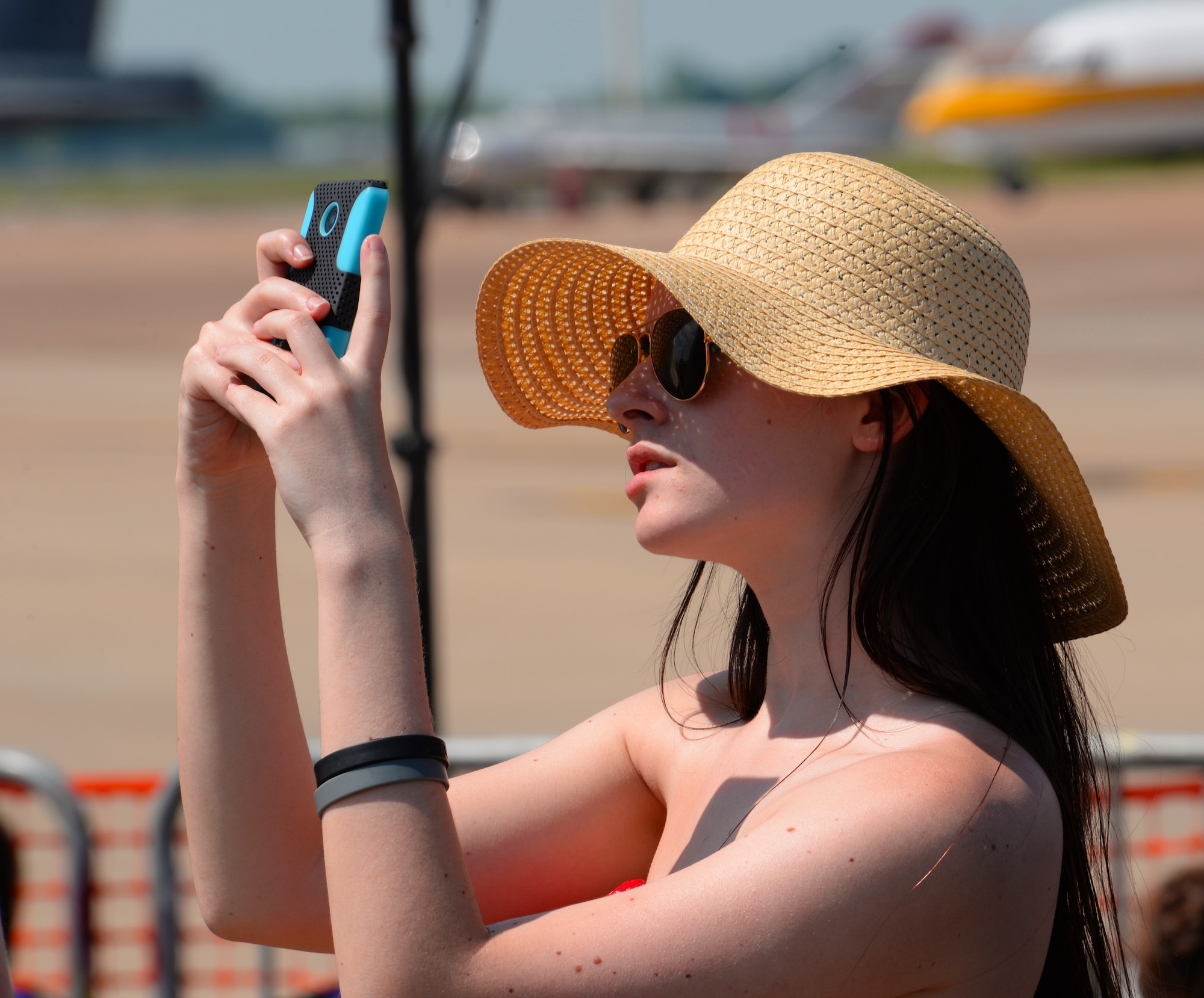 A woman takes a photo as she watches the U.S. Navy Flight Demonstration Team Blue Angels F/A-18 Hornets perform during the 2015 Defenders of Liberty Airshow at Barksdale Air Force Base, Louisiana, May 2. The air show, which drew an estimated 60,000 people per day, featured attractions such as the Blue Angels, the U.S. Army Parachute Team “Golden Knights," and a flyover by the bomber fleet . (U.S. Air Force photo/Airman 1st Class Curt Beach)