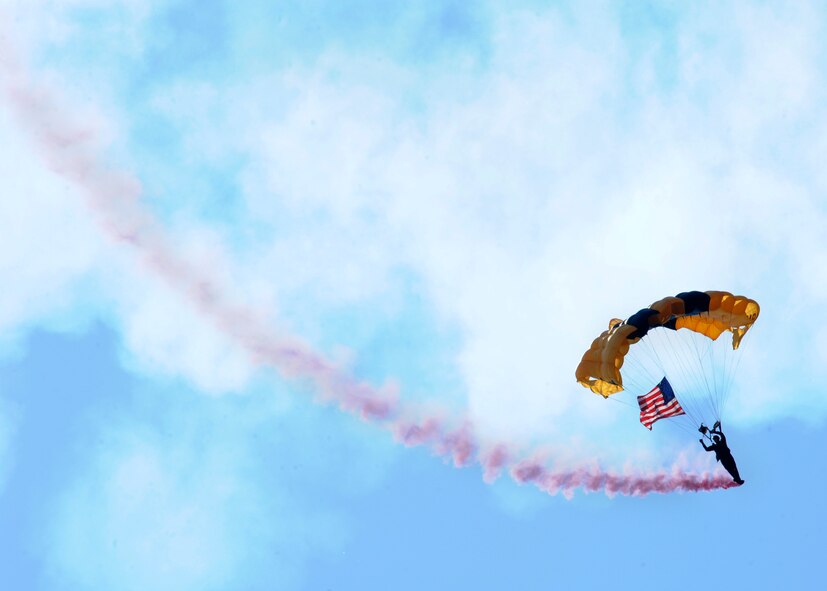 U.S. Army Golden Knights do an aerial performance during the 2015 Defenders of Liberty Airshow on Barksdale Air Force Base, Louisiana, May 3. The American Flag was flown during the National Anthem to signal the start of the air show. (U.S. Air Force photo/Senior Airman Joseph A. Pagán Jr.)