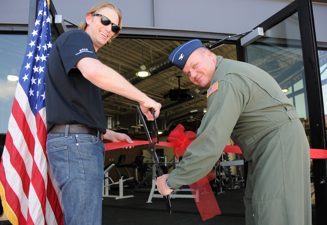 Col. Gary Brewer, 161st Air Refueling Wing commander, and Brandon Carr of the contracted construction crew, commemorate the wing’s new fitness center at a ribbon cutting ceremony at the Phoenix Air National Guard base, May 2. At 2,400 square-feet, the first ever stand-alone fitness center to be built on an Air National Guard base after the base’s original construction will accommodate nearly twice as many Airmen as the old facility. (U.S. Air National Guard photo by Tech. Sgt. Courtney Enos)