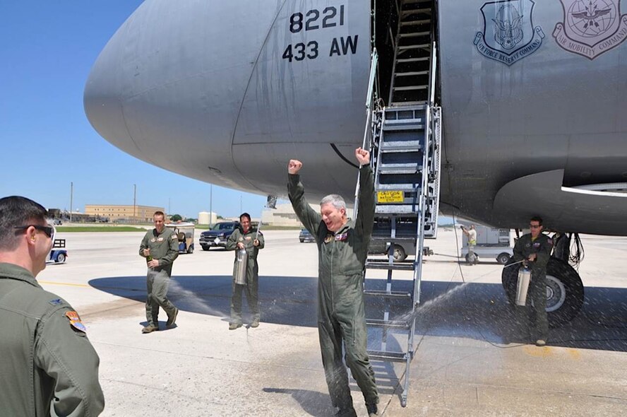 Members of the 433rd Airlift Wing greet Col. Aaron G. Vangelisti, 433rd  AW vice commander with a spray of water after his fini flight, May 1, 2015, at Joint Base San Antonio-Lackland, Texas. Vangelisti leaves the "Alamo Wing" to serve as the Fourth Air Force vice commander at March Air Reserve Base, California. (U.S. Air Force Photo/Capt. Philip Cortez)