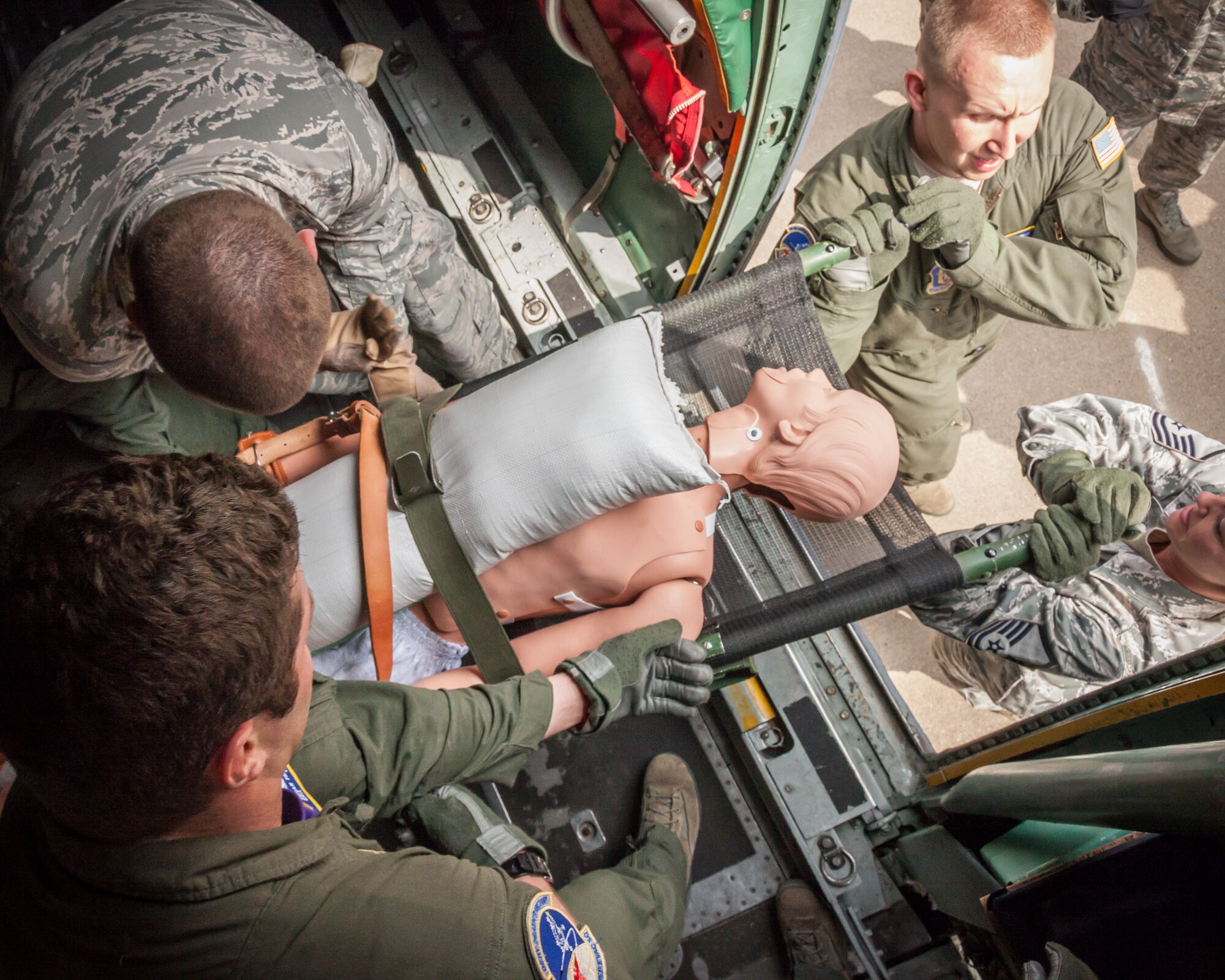 Members of the 934th Aeromedical Evacuation Squadron unload a patient from aboard a C-130 aircraft during an obstacle course exercise.  934 AES Airmen brushed up on skills and competed in challenges during a block training session April 30 and May 1 at the Minneapolis-St. Paul Air Reserve Station, Minn.  (U.S. Air Force photo by Shannon McKay/Released)