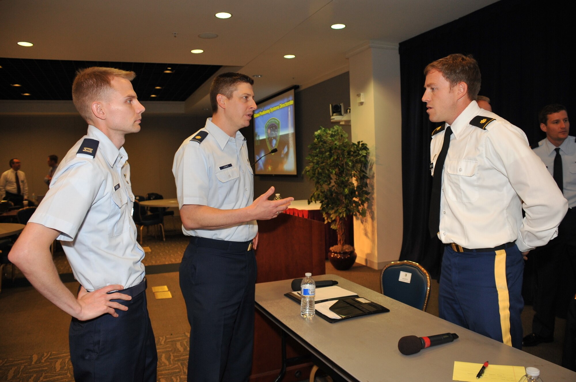 U.S. Air Force Maj. Steve Lewis from the Headquarters Reserve National Security Space Institute, center, and Capt. Paul Rogers, Air Force Space Command Advanced Space Operations School, left, speak to a U.S. Army Warfighter about developing advanced training for conducting Navigation Warfare operations in contested, degraded and operationally-limited (CDO) domains. The RNSSI and ASOPS, both located at the Moorman Space Education and Training Center at Peterson Air Force Base in Colorado Springs, Colo., provides support to the warfighter through the research, development and world-class instruction of space system technologies, capabilities, operational concepts, acquisitions and tactics in support of joint service strategies to develop certified space professionals across the Department of Defense. (U.S. Air Force photo by Tech. Sgt. Sarah Corrice/Released)