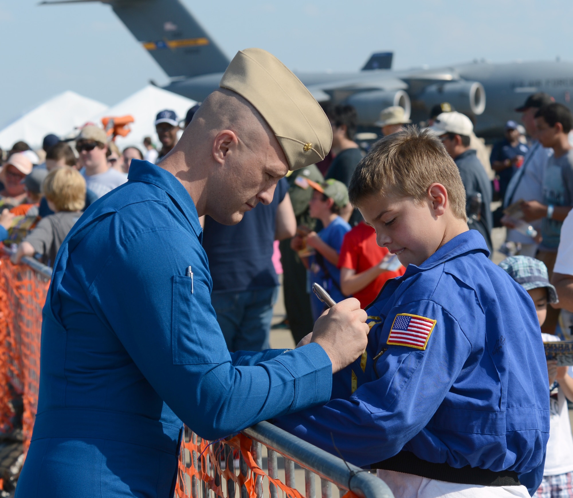Maj. Dusty Cook, U.S. Navy Flight Demonstration Team Blue Angels U.S. Marine Corps C-130 pilot, signs the jacket of a fan on Barksdale Air Force Base, Louisiana, May 2, 2015. Maj. Cook, who has more than 2,100 flight hours, visited the base to perform in the 2015 Defenders of Liberty Airshow in front of a crowd of more than 60,000 spectators. (U.S. Air Force photo/Airman 1st Class Curt Beach)