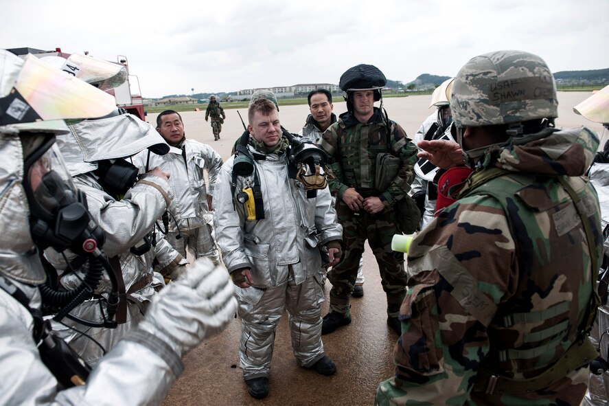 Master Sgt. Shawn Chenault, 8th Civil Engineer Squadron assistant fire chief and wing inspection team member, instructs Airmen from the 8th CES Fire Department on how to extinguish a simulated aircraft fire during Exercise Beverly Midnight 15-3 April 29, 2015, at Kunsan Air Base, Republic of Korea.  Managed by the 8th Fighter Wing inspector general’s office, WIT members injected realistic exercise scenarios aimed at sharpening the Wolf Pack’s ability to defend the base. (U.S. Air Force photo by Senior Airman Katrina Heikkinen/Released)