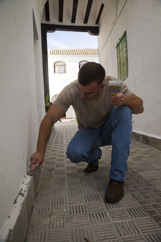 U.S. Marine Cpl. George Mason, a flight equipment technician with Special-Purpose Marine Air-Ground Task Force Crisis Response-Africa, removes loose paint from a wall of the Santa Clara convent in Morón, Spain, April 23, 2015. Marines with SPMAGTF-CR-AF visited the convent as a way to give back to the community in Morón, where they are stationed as a rotational crisis-response force. (U.S. Marine Corps photo by Sgt. Paul Peterson/Released)