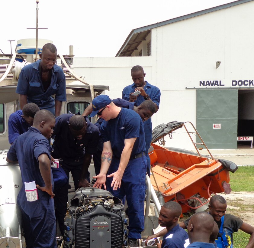 U.S. Coast Guardsmen Machine Technician 2nd Class Kevin Wilson, a boat mechanic with Special-Purpose Marine Air-Ground Task Force Crisis Response-Africa explains proper engine maintenance to Ghanaian Sailors at the Sigondi Western Naval Base in Ghana, April 14, 2015. A team of four U.S. Marines and Coast Guardsmen taught more than 25 Ghanaian Sailors boat maintenance on the 27-foot Defender-class boat. (Courtesy Photo/Released)