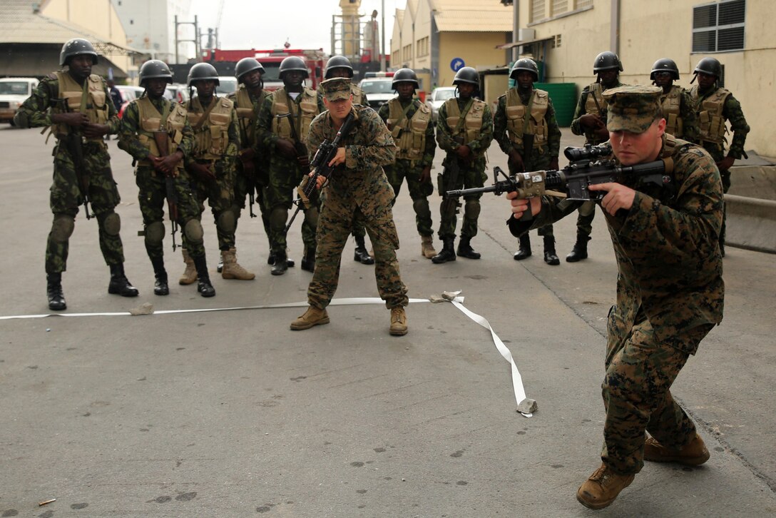 U.S. Marine Cpl. Anthony Bourne (right) and Lance Cpl. Daniel Maine, riflemen with Special-Purpose Marine Air-Ground Task Force Crisis Response-Africa, demonstrate room-clearing techniques to Angolan Marines in Luanda, Angola, March 4, 2015. U.S. Marines, British Royal Marines and Spanish Marines spent three days training with the Angolans in close-quarters combat, small boat operations and repair, and visit, board, search and seizure techniques before departing for Cameroon during the maritime security exercise, Africa Partnership Station. (Official U.S. Marine Corps photo by Staff Sgt. Steve Cushman/Released)