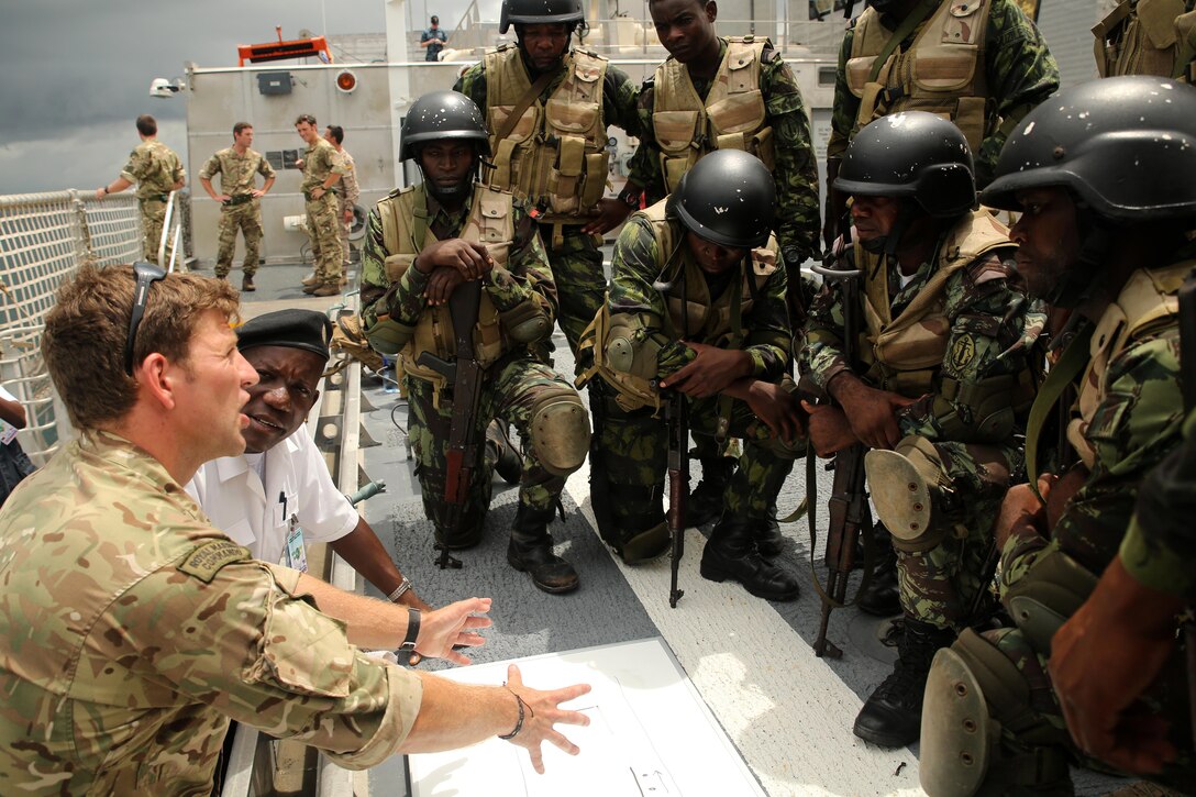British Royal Marine Sgt. Lloyd Hartley (left) discusses search and seizure tactics with Angolan Marines, also known as Fuzileiros Navais da Marinha de Guerra Angolana (MGA), in Luanda, Angola, March 4, 2015. U.S. Marines, British Royal Marines and Spanish Marines spent three days working with the Angolans in close-quarters combat, small boat operations and repair, and search and seizure techniques before departing for Cameroon during the maritime security exercise, Africa Partnership Station. (Official U.S. Marine Corps photo by Staff Sgt. Steve Cushman/Released)