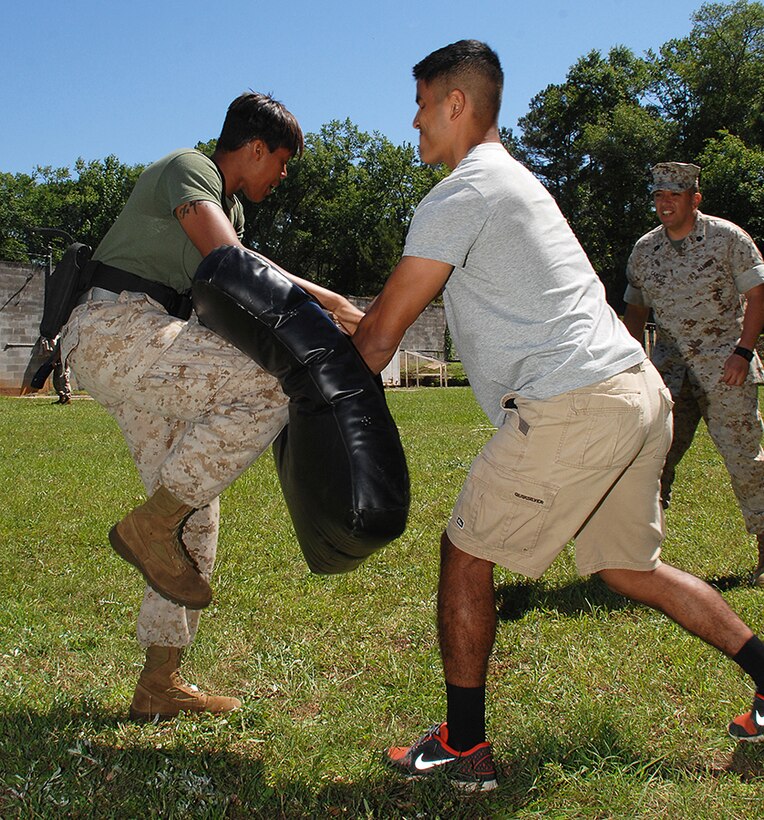 Security Augment Force student Sgt. Candice Thomas conducts a knee strike after receiving a stream of Oleoresin Capsicum spray, better known as pepper spray, during nonlethal weapons training hosted by Marine Corps Logistics Base Albany’s Marine Corps Police Department, May 1. She fought through the course blindly throwing punches, knee strikes and baton strikes. 