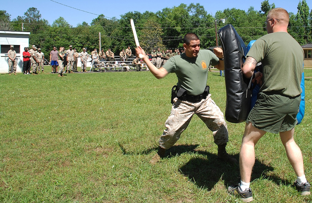 Security Augmentation Force student Staff Sgt. Fransciso Castro, after receiving a stream of oleoresin capsicum spray, navigates through an obstacle course of Marines holding pads, representing potential attackers during a nonlethal weapons training class hosted by Marine Corps Logistics Base Albany’s Marine Corps Police Department, May 1. He fought through the course blindly throwing punches, knee strikes and baton strikes.  