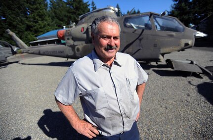 Tom Wojnar, a Washington State Department of Natural Resources helicopter mechanic and Army Vietnam War veteran, stands in front of the AH-1G Cobra helicopter at a DNR property in Tumwater, Wash., Oct. 6, 2010. The "Virginia Rose II" flew into the history books as the first AH-1G to fly in Vietnam on Sept. 4, 1967.